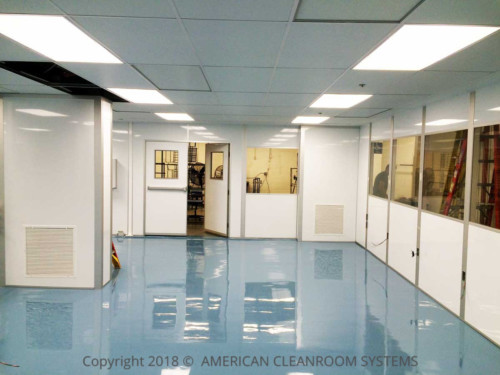 blue shiny epoxy floor, white modular cleanroom walls, yellow windows, interior of cleanroom