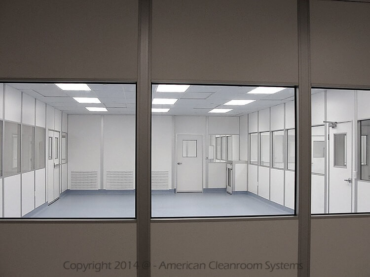 view into modular cleanroom thru windows, blue heat welded vinyl cleanroom flooring, low wall cleanroom air returns