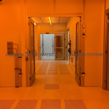 amber lighting, interior class 100 cleanroom, interior class 100 cleanroom, open cleanroom doors, piping on walls