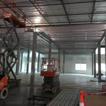 steel columns, partially installed modular cleanroom, roof deck, scissor lift