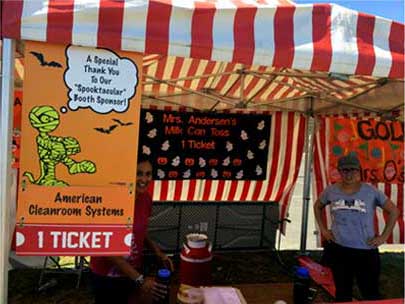 Tent and volunteers with American Cleanroom Systems Sponsored banner