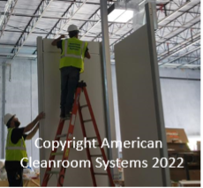 cleanroom walls being installed, installer on ladder