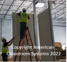 cleanroom walls being installed, installer on ladder