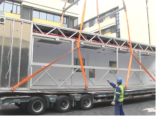 modular room being liftoff off flatbed