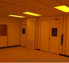 interior of class 1000 modular cleanroom, amber lighting, cleanroom doors, low wall air return