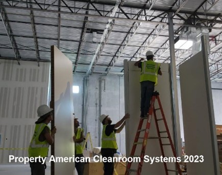 four construction workers, assembling cleanroom walls
